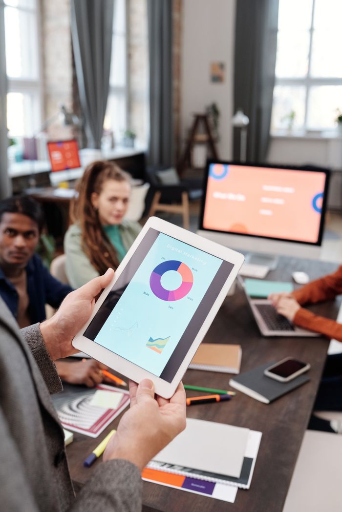 contact-img Colleagues reviewing business data on a tablet in a modern office setting.
